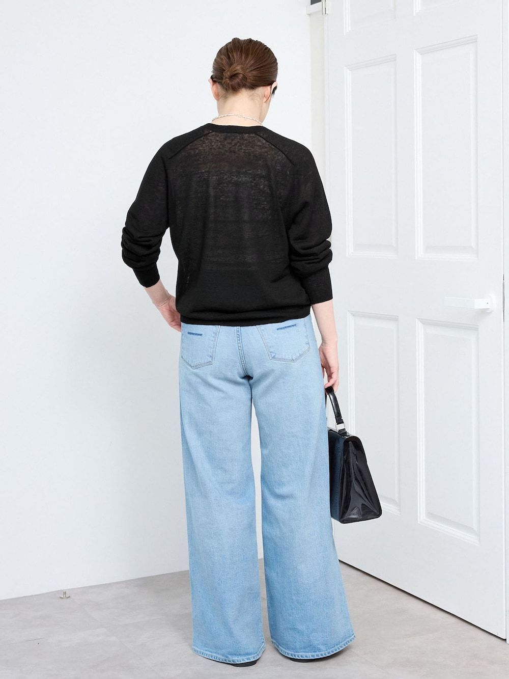 ブルー系のデニムパンツ、ブラック系のカーディガン/ボレロを着用したレディースの春コーディネートの2枚目の写真