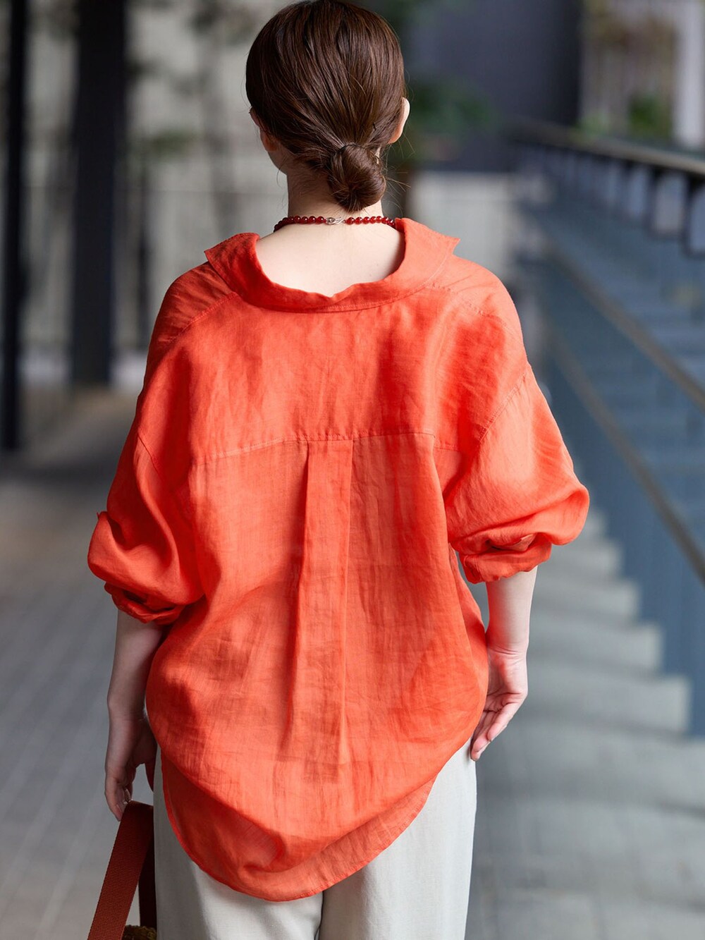 ベージュ系のその他パンツ、レッド系のシャツ/ブラウス、イエロー系のハンドバッグを着用したレディースの春コーディネートの5枚目の写真