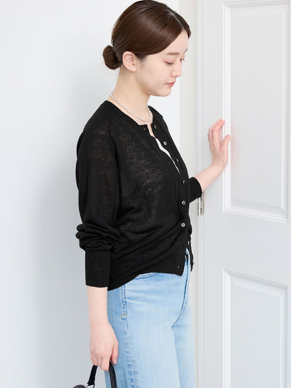 ブルー系のデニムパンツ、ブラック系のカーディガン/ボレロを着用したレディースの春コーディネートの4枚目の写真