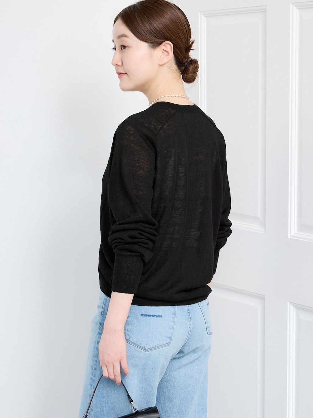 ブルー系のデニムパンツ、ブラック系のカーディガン/ボレロを着用したレディースの春コーディネートの5枚目の写真