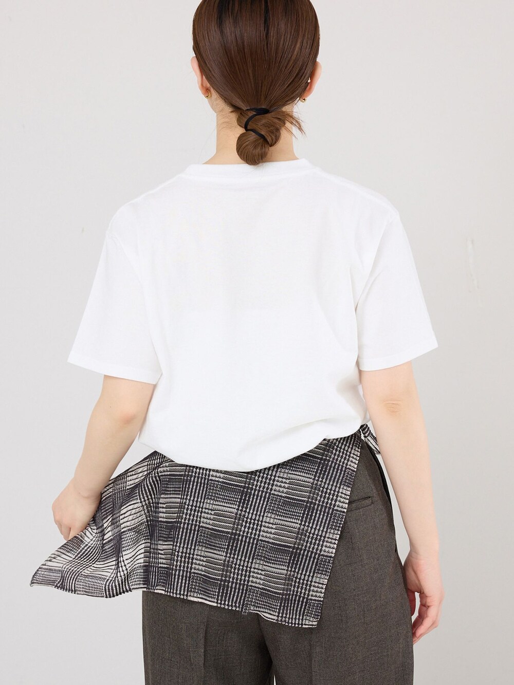 ブラウン系のスラックス、ホワイト系のTシャツ/カットソー、ブラック系のサンダルを着用したレディースの春コーディネートの5枚目の写真