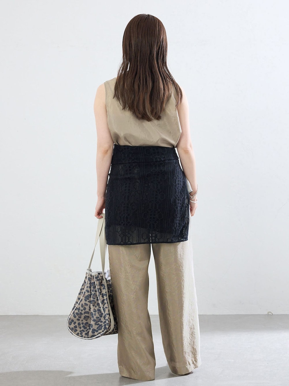 ベージュ系のその他パンツ、ベージュ系のシャツ/ブラウス、ブラウン系のトートバッグを着用したレディースの夏コーディネートの3枚目の写真