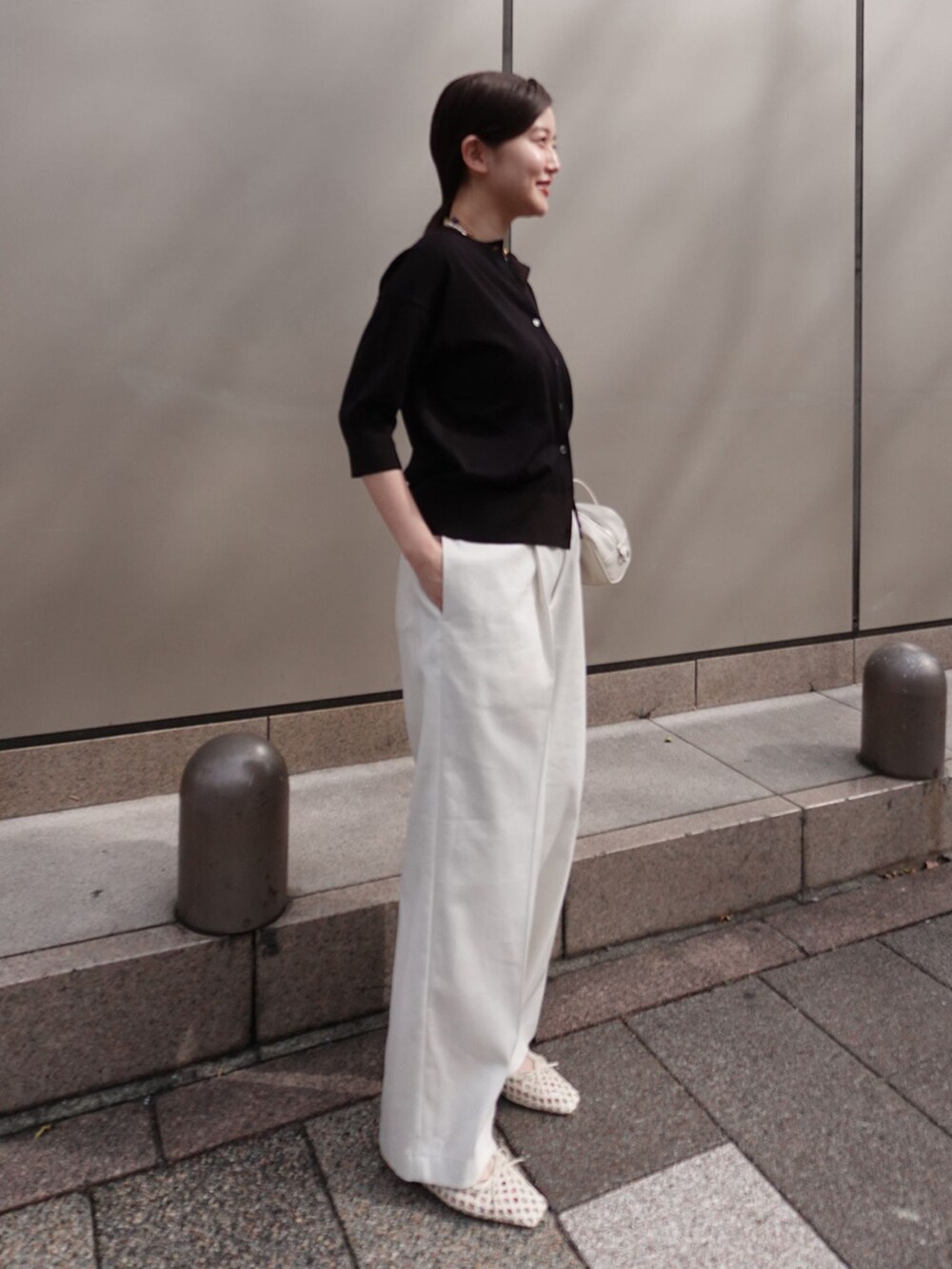 ホワイト系のチノパンツ、ホワイト系のショルダーバッグ、ホワイト系のバレエシューズを着用したレディースの春コーディネートの2枚目の写真