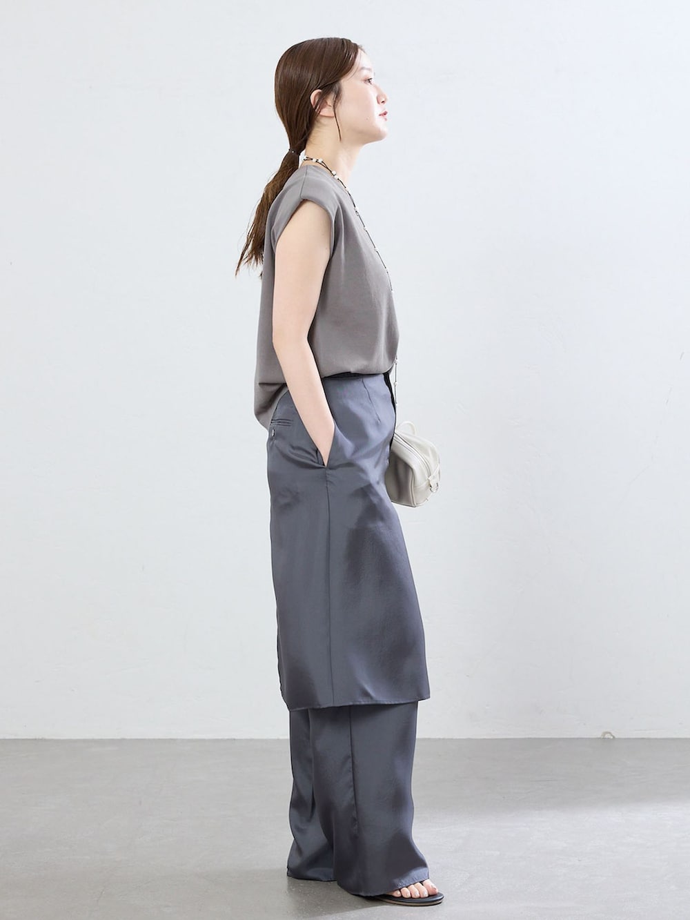 グレー系のその他パンツ、グレー系のニット/セーター、ブラック系のサンダルを着用したレディースの夏コーディネートの2枚目の写真