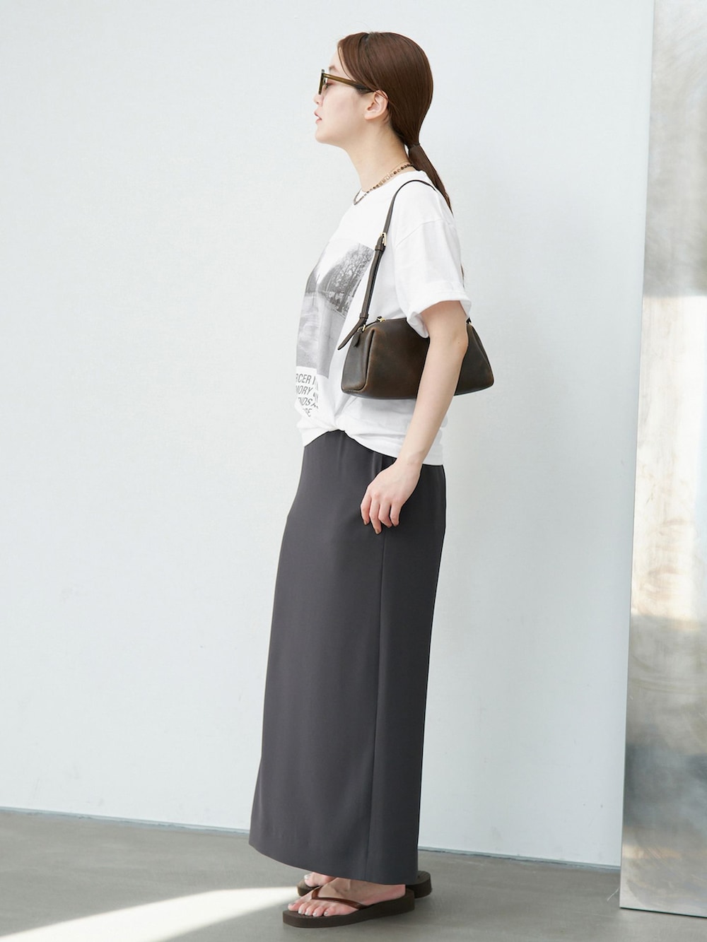 グリーン系のスカート、ホワイト系のTシャツ/カットソーを着用したレディースの夏コーディネートの2枚目の写真