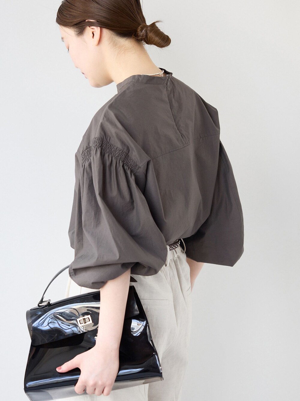 ベージュ系のスラックス、グレー系のシャツ/ブラウス、ブラック系のサンダルを着用したレディースの春コーディネートの5枚目の写真