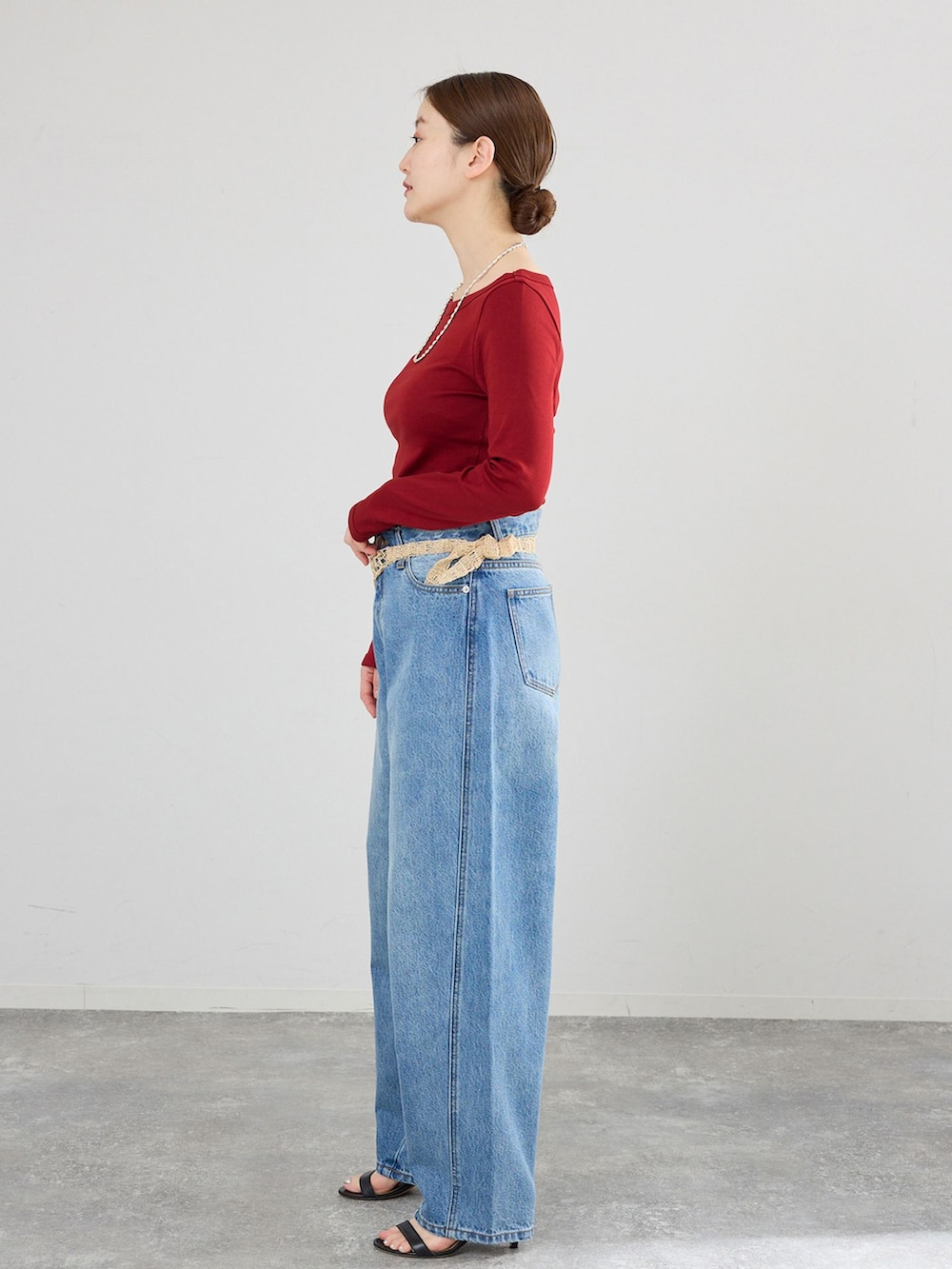 ブルー系のデニムパンツ、レッド系のTシャツ/カットソーを着用したレディースの冬コーディネートの2枚目の写真