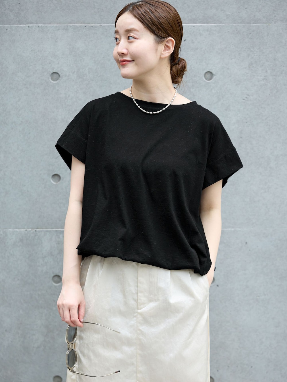 ホワイト系のスカート、ブラック系のTシャツ/カットソー、ブラック系のサンダルを着用したレディースの夏コーディネートの4枚目の写真