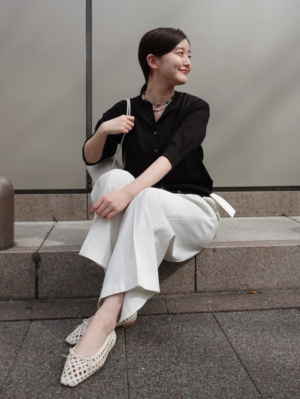 ホワイト系のチノパンツ、ホワイト系のショルダーバッグ、ホワイト系のバレエシューズを着用したレディースの春コーディネートの3枚目の写真