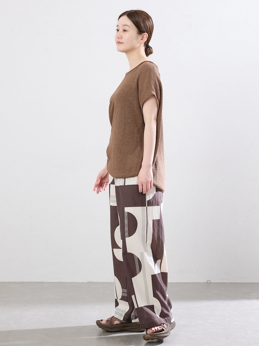 ブラウン系のその他パンツ、ブラウン系のニット/セーター、ブラウン系のサンダルを着用したレディースの春コーディネートの2枚目の写真