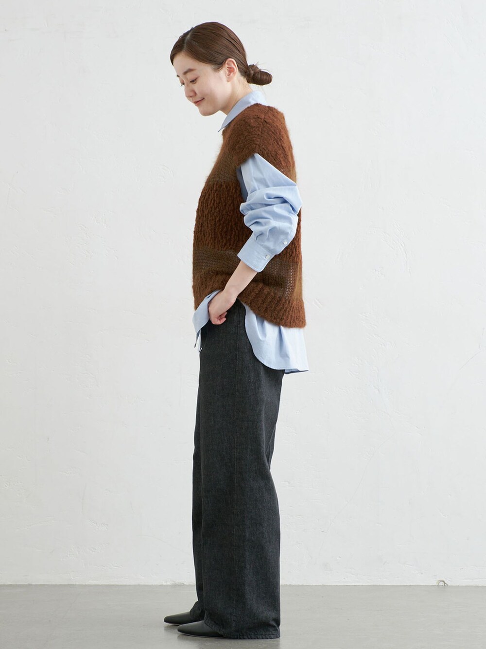 ブラック系のデニムパンツ、ブルー系のシャツ/ブラウス、ブラウン系のベストを着用したレディースの秋コーディネートの2枚目の写真