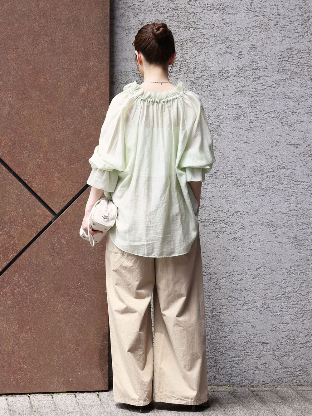 ベージュ系のその他パンツ、グリーン系のシャツ/ブラウス、ホワイト系のショルダーバッグを着用したレディースの春コーディネートの3枚目の写真
