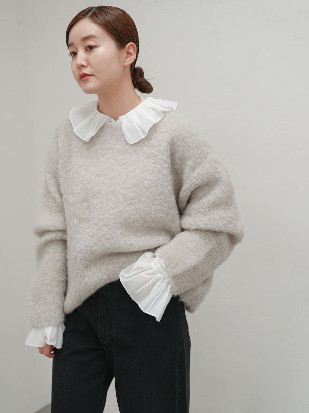 ブラック系のデニムパンツ、ホワイト系のシャツ/ブラウス、グレー系のニット/セーターを着用したレディースの秋コーディネートの3枚目の写真