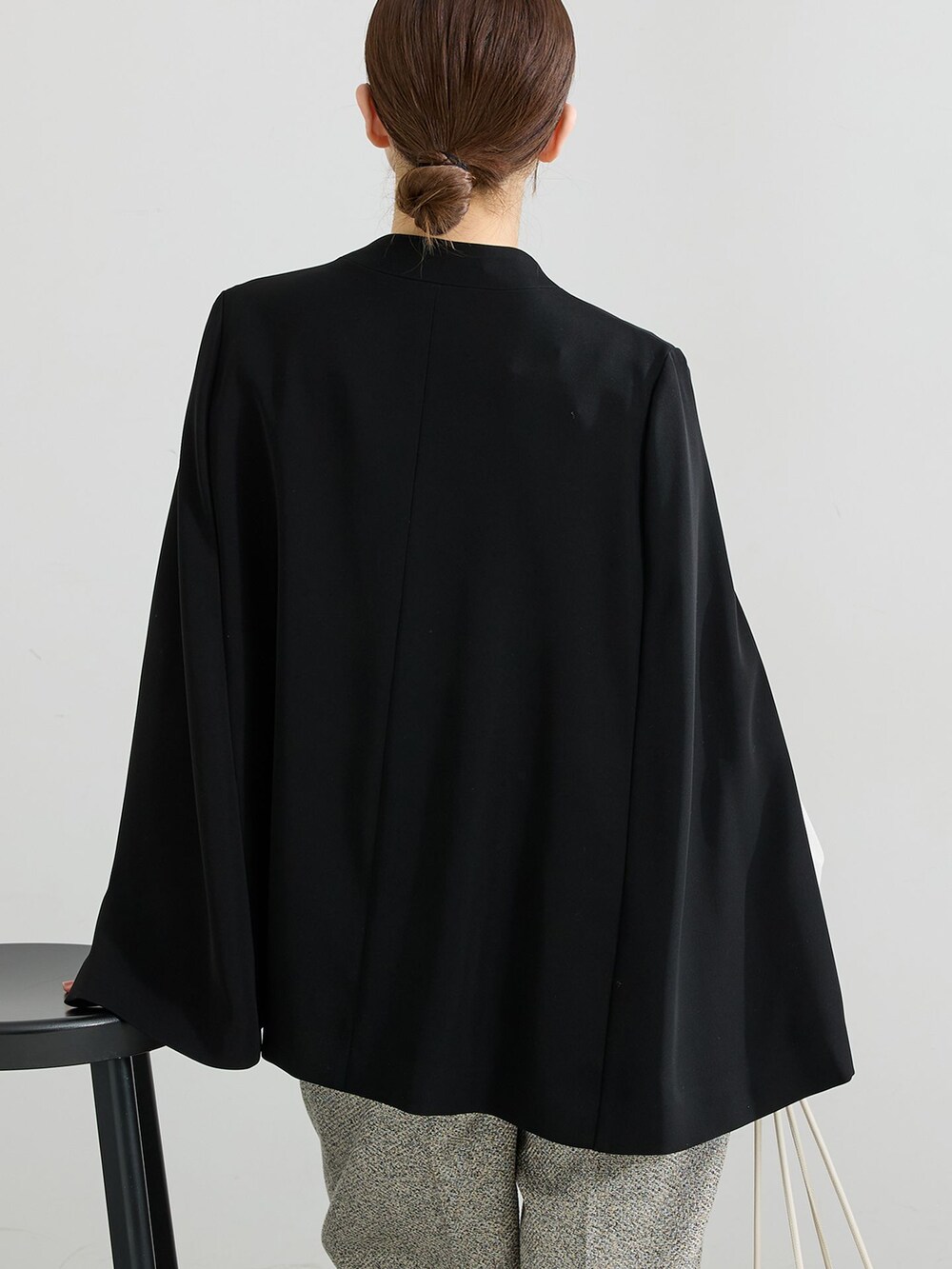 ブラック系のパンプス、ブラック系のその他アウター、ホワイト系のショルダーバッグを着用したレディースの冬コーディネートの5枚目の写真