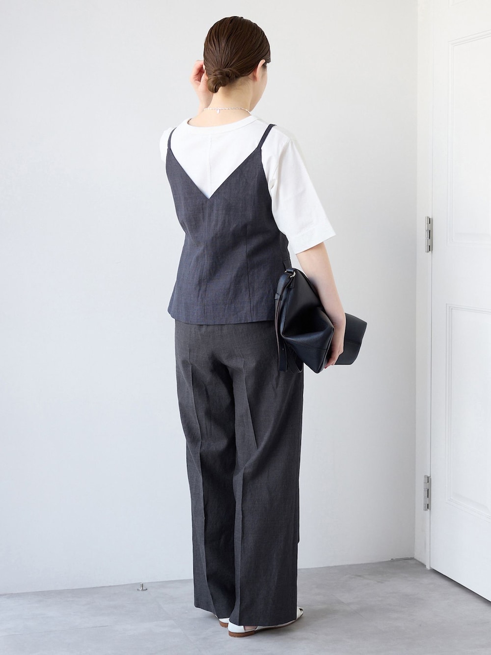 ブラック系のベスト、ブラック系のスラックス、ホワイト系のTシャツ/カットソーを着用したレディースの春コーディネートの3枚目の写真