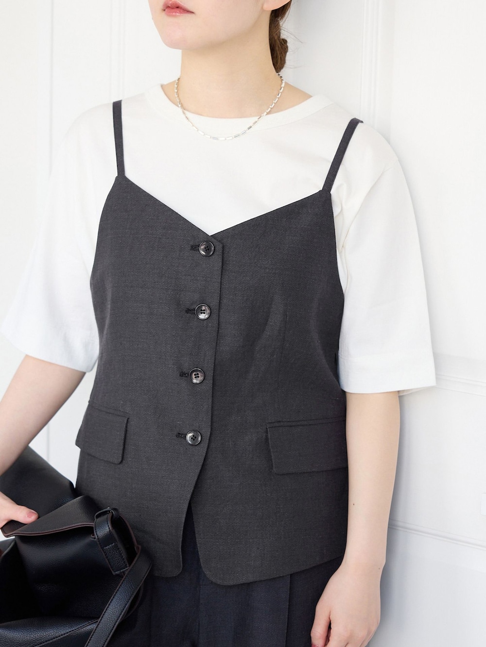 ブラック系のベスト、ブラック系のスラックス、ホワイト系のTシャツ/カットソーを着用したレディースの春コーディネートの4枚目の写真