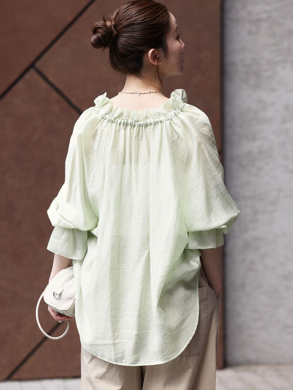 ベージュ系のその他パンツ、グリーン系のシャツ/ブラウス、ホワイト系のショルダーバッグを着用したレディースの春コーディネートの5枚目の写真