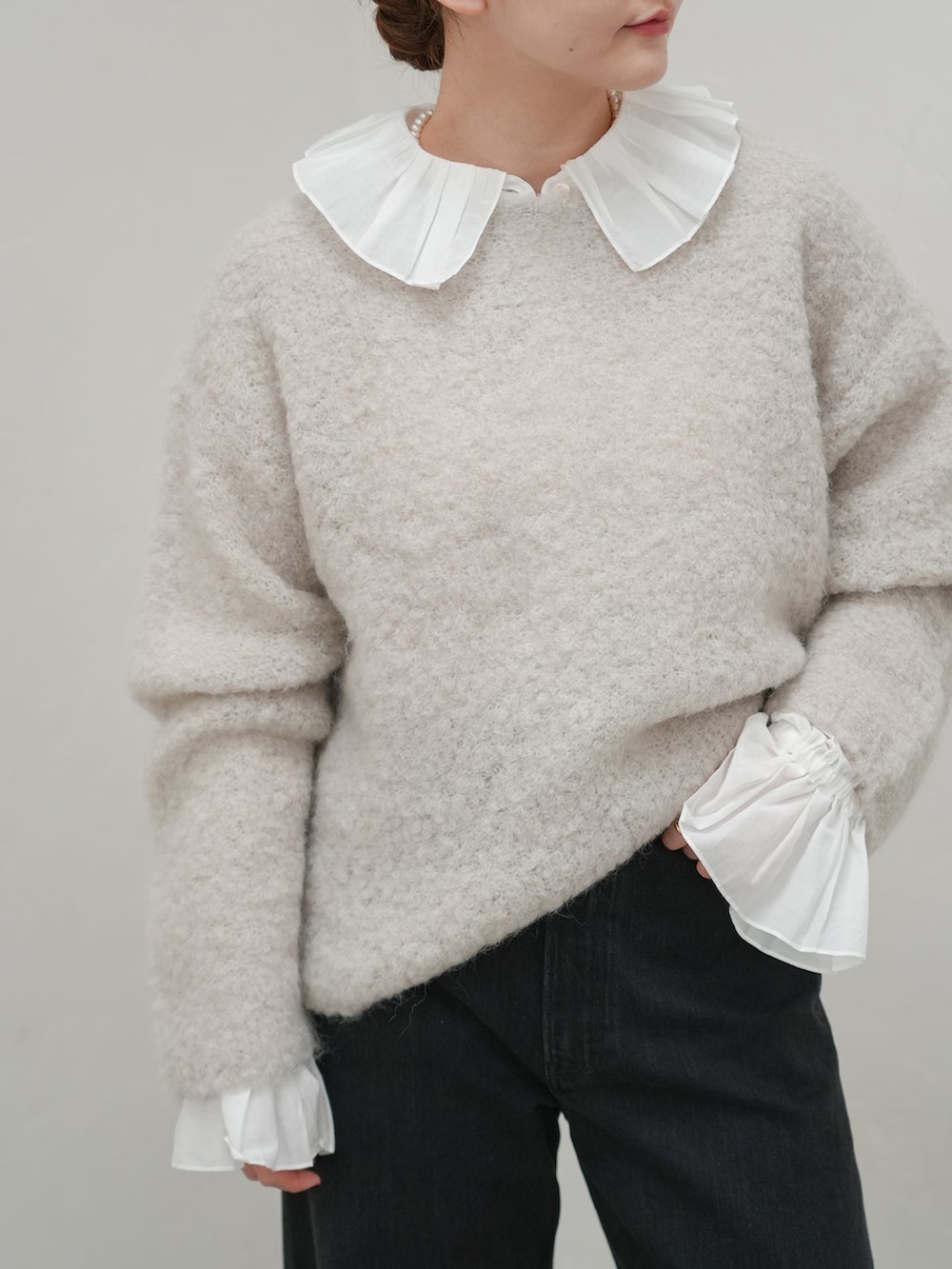 ブラック系のデニムパンツ、ホワイト系のシャツ/ブラウス、グレー系のニット/セーターを着用したレディースの秋コーディネートの4枚目の写真