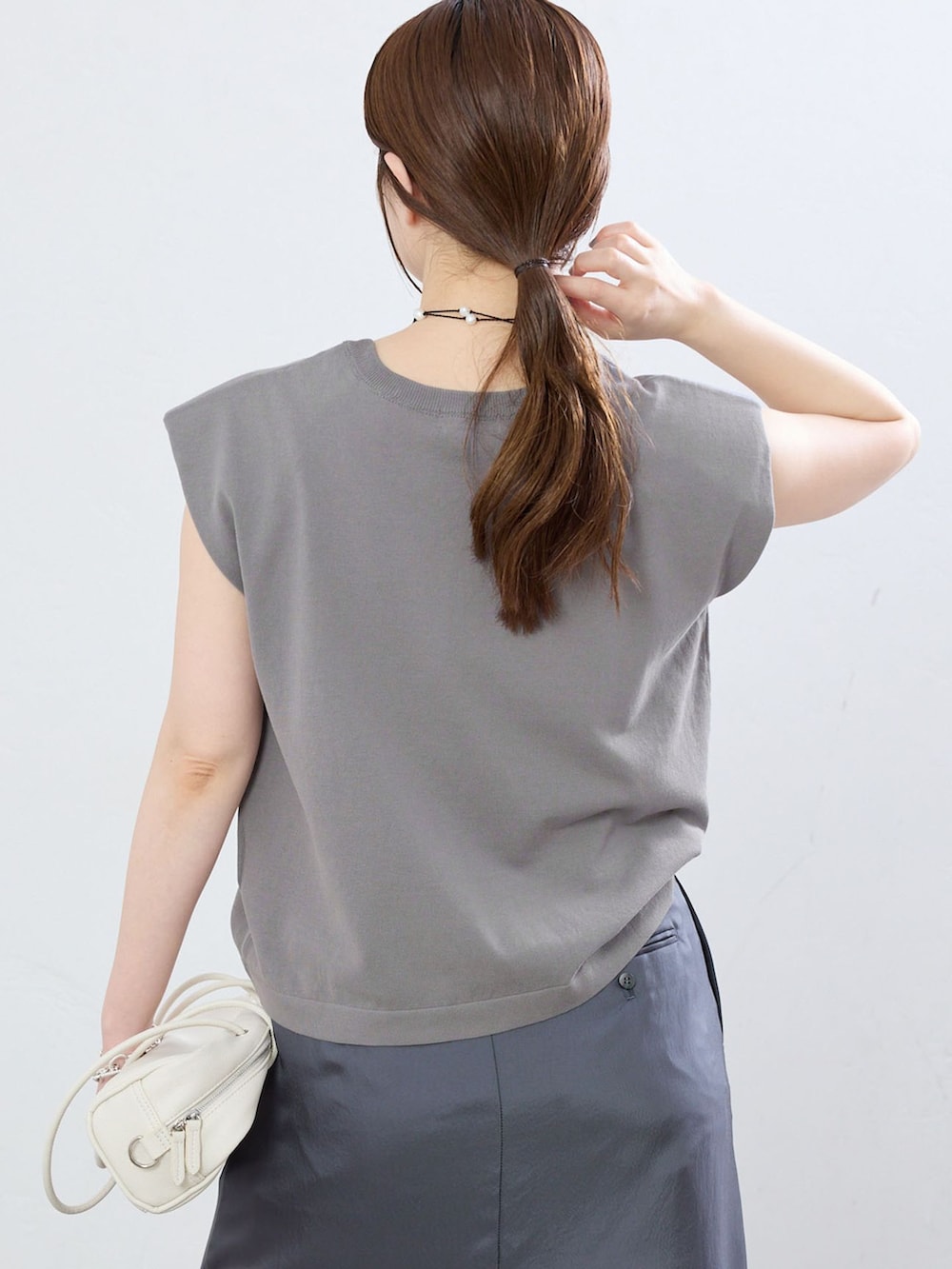 グレー系のその他パンツ、グレー系のニット/セーター、ブラック系のサンダルを着用したレディースの夏コーディネートの5枚目の写真
