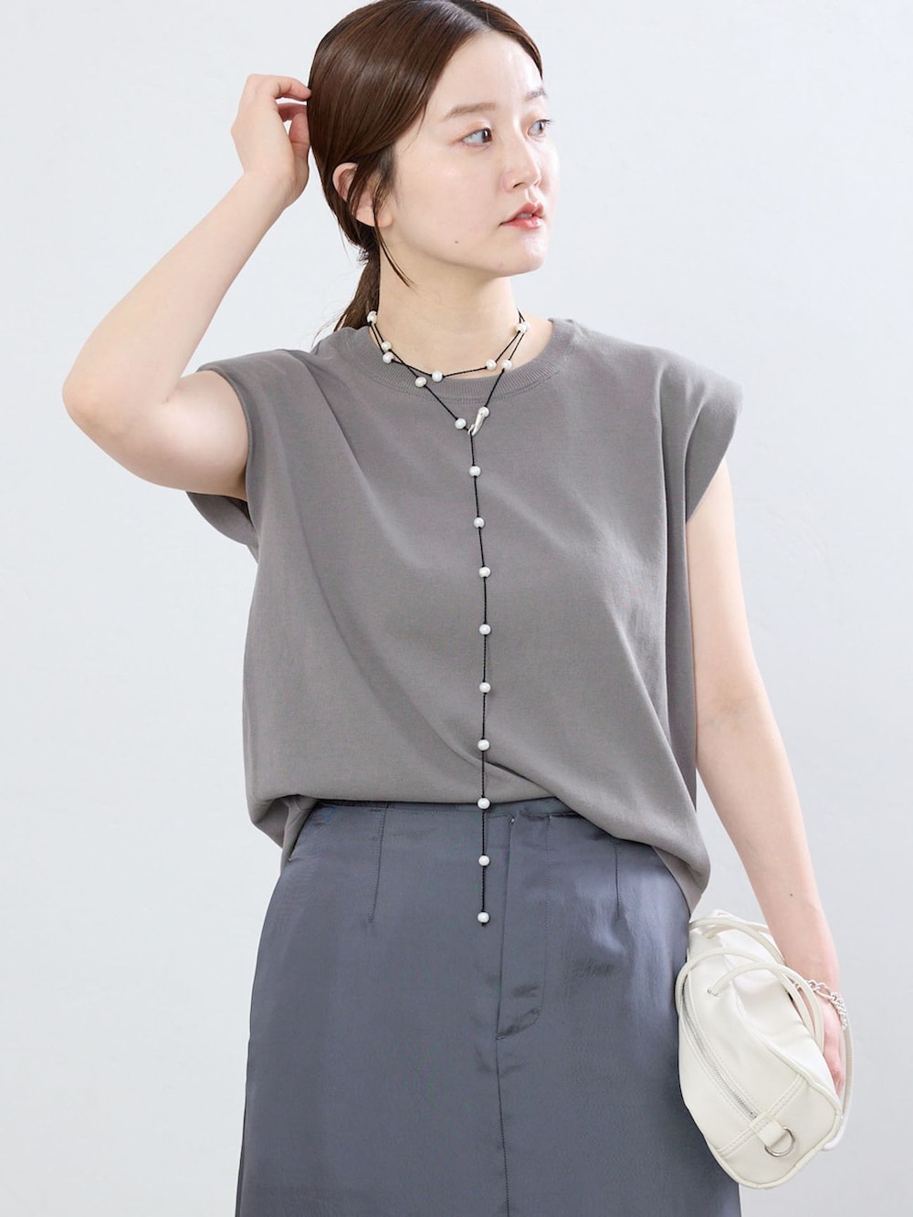 グレー系のその他パンツ、グレー系のニット/セーター、ブラック系のサンダルを着用したレディースの夏コーディネートの4枚目の写真