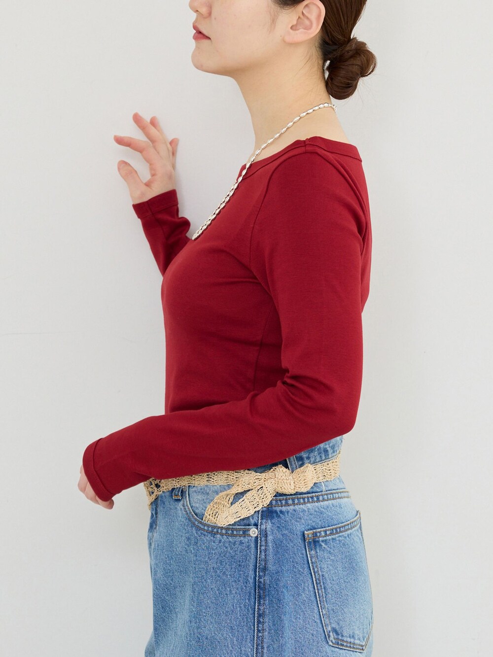 ブルー系のデニムパンツ、レッド系のTシャツ/カットソーを着用したレディースの冬コーディネートの4枚目の写真