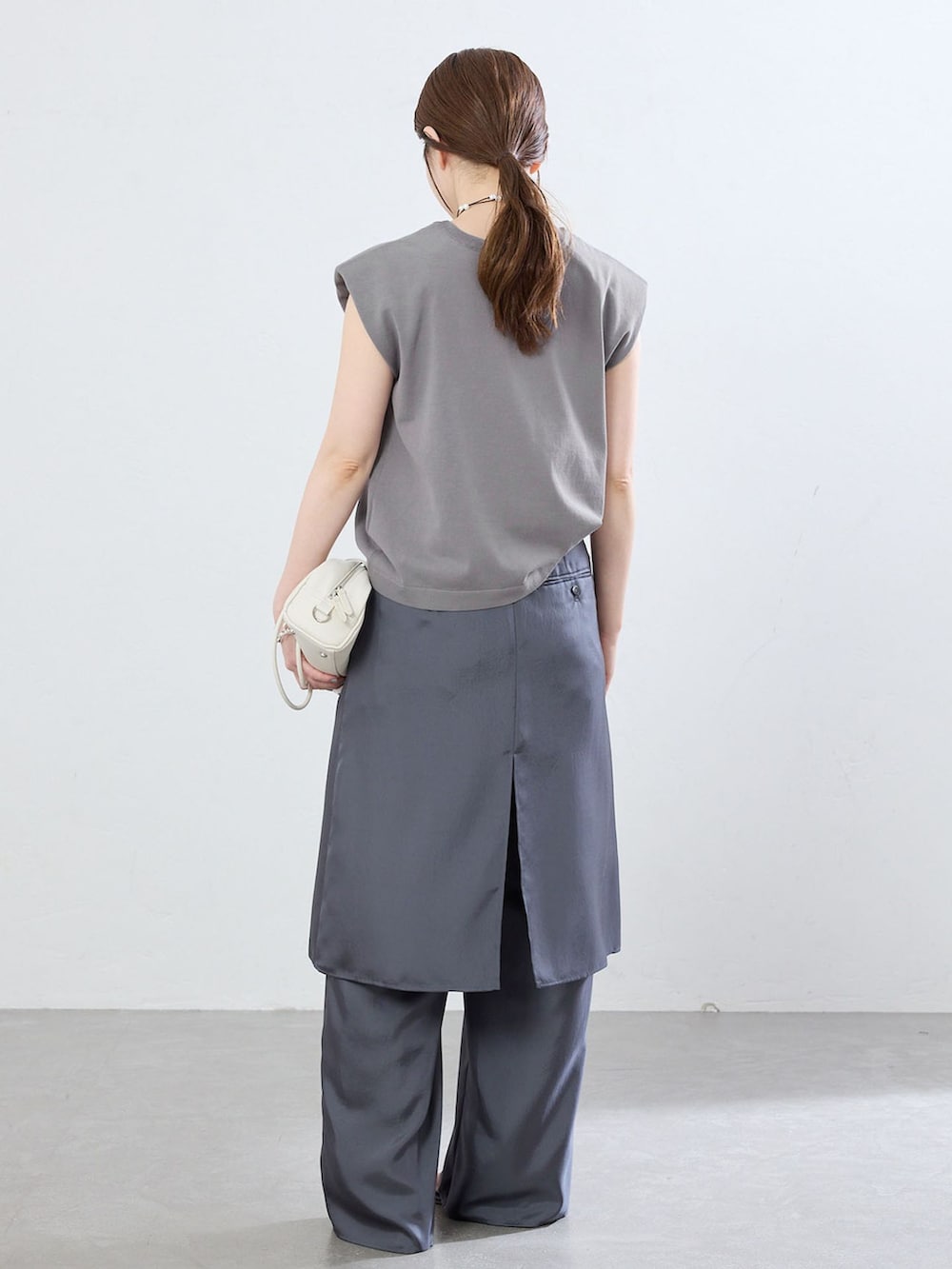 グレー系のその他パンツ、グレー系のニット/セーター、ブラック系のサンダルを着用したレディースの夏コーディネートの3枚目の写真