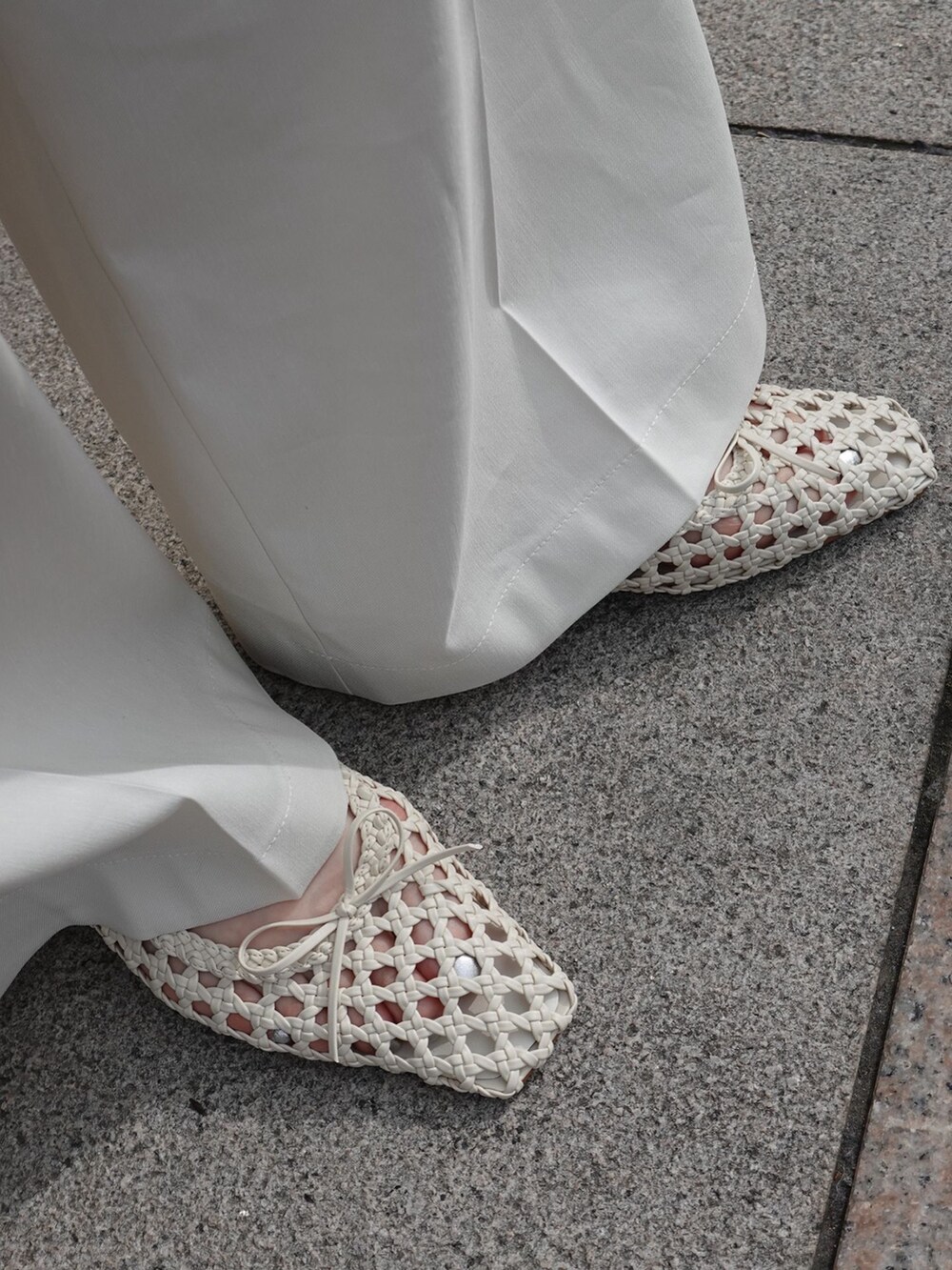 ホワイト系のチノパンツ、ホワイト系のショルダーバッグ、ホワイト系のバレエシューズを着用したレディースの春コーディネートの7枚目の写真
