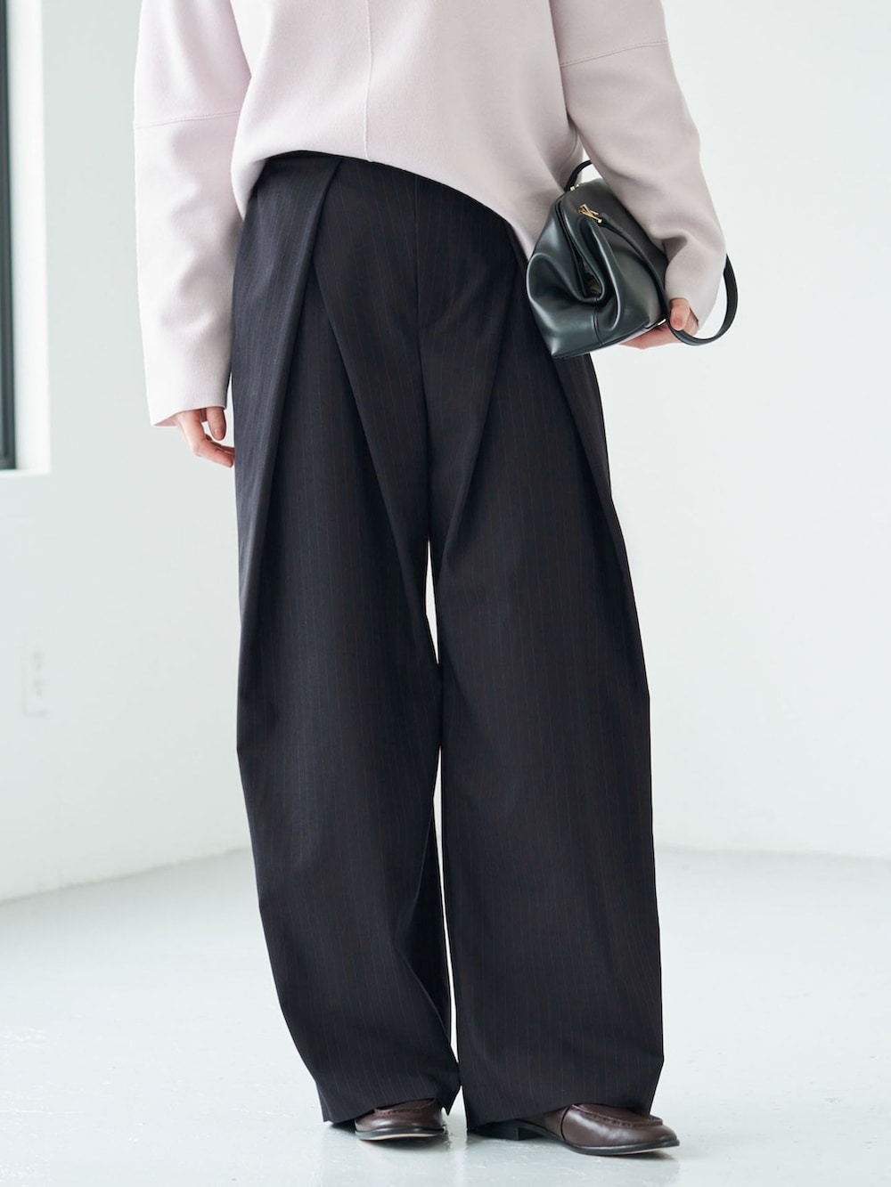 ブルー系のその他パンツ、ピンク系のニット/セーター、ブラック系のハンドバッグを着用したレディースの秋コーディネートの6枚目の写真