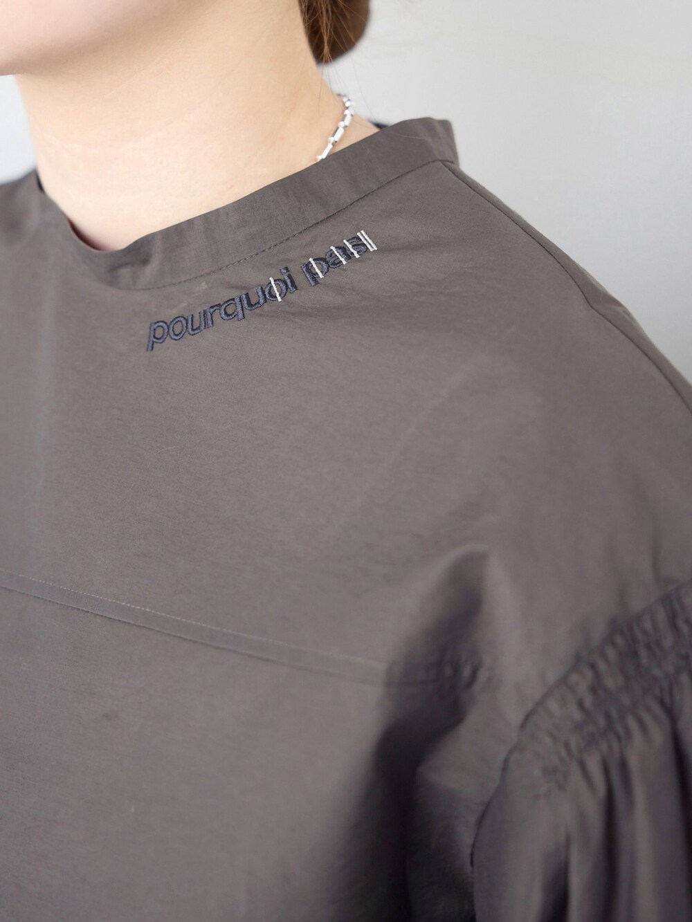 ベージュ系のスラックス、グレー系のシャツ/ブラウス、ブラック系のサンダルを着用したレディースの春コーディネートの6枚目の写真