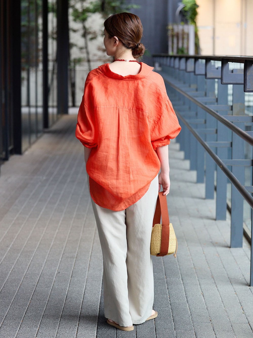 ベージュ系のその他パンツ、レッド系のシャツ/ブラウス、イエロー系のハンドバッグを着用したレディースの春コーディネートの3枚目の写真