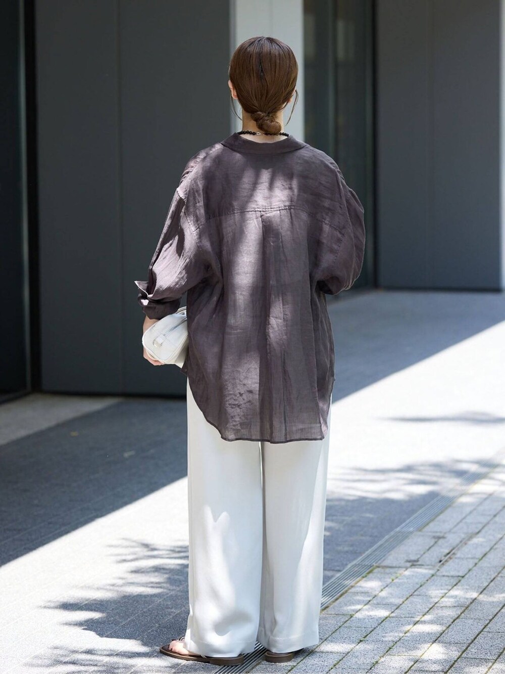 ベージュ系のその他パンツ、ブラック系のシャツ/ブラウス、ホワイト系のショルダーバッグを着用したレディースの春コーディネートの3枚目の写真