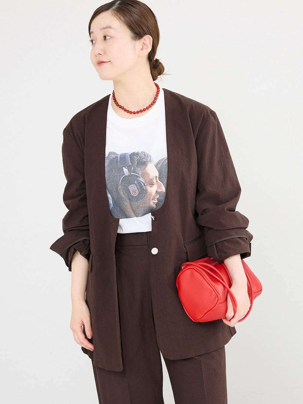 ブラウン系のノーカラージャケット、ブラウン系のスラックス、ホワイト系のTシャツ/カットソーを着用したレディースの春コーディネートの3枚目の写真
