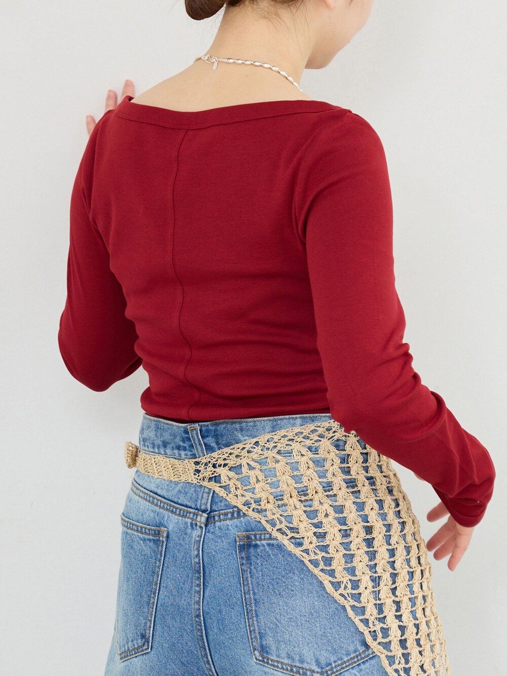ブルー系のデニムパンツ、レッド系のTシャツ/カットソーを着用したレディースの冬コーディネートの5枚目の写真