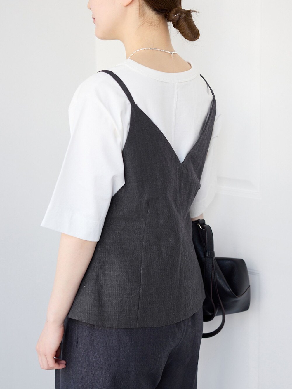 ブラック系のベスト、ブラック系のスラックス、ホワイト系のTシャツ/カットソーを着用したレディースの春コーディネートの5枚目の写真