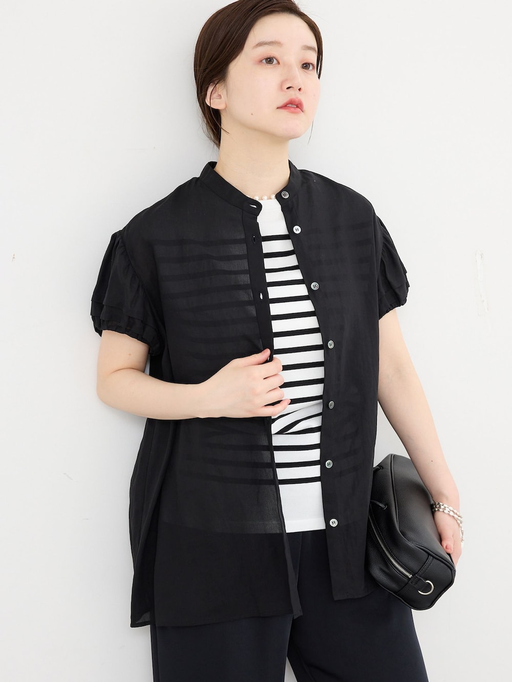 ブラック系のその他パンツ、ブラック系のシャツ/ブラウス、ブラック系のニット/セーターを着用したレディースの春コーディネートの4枚目の写真