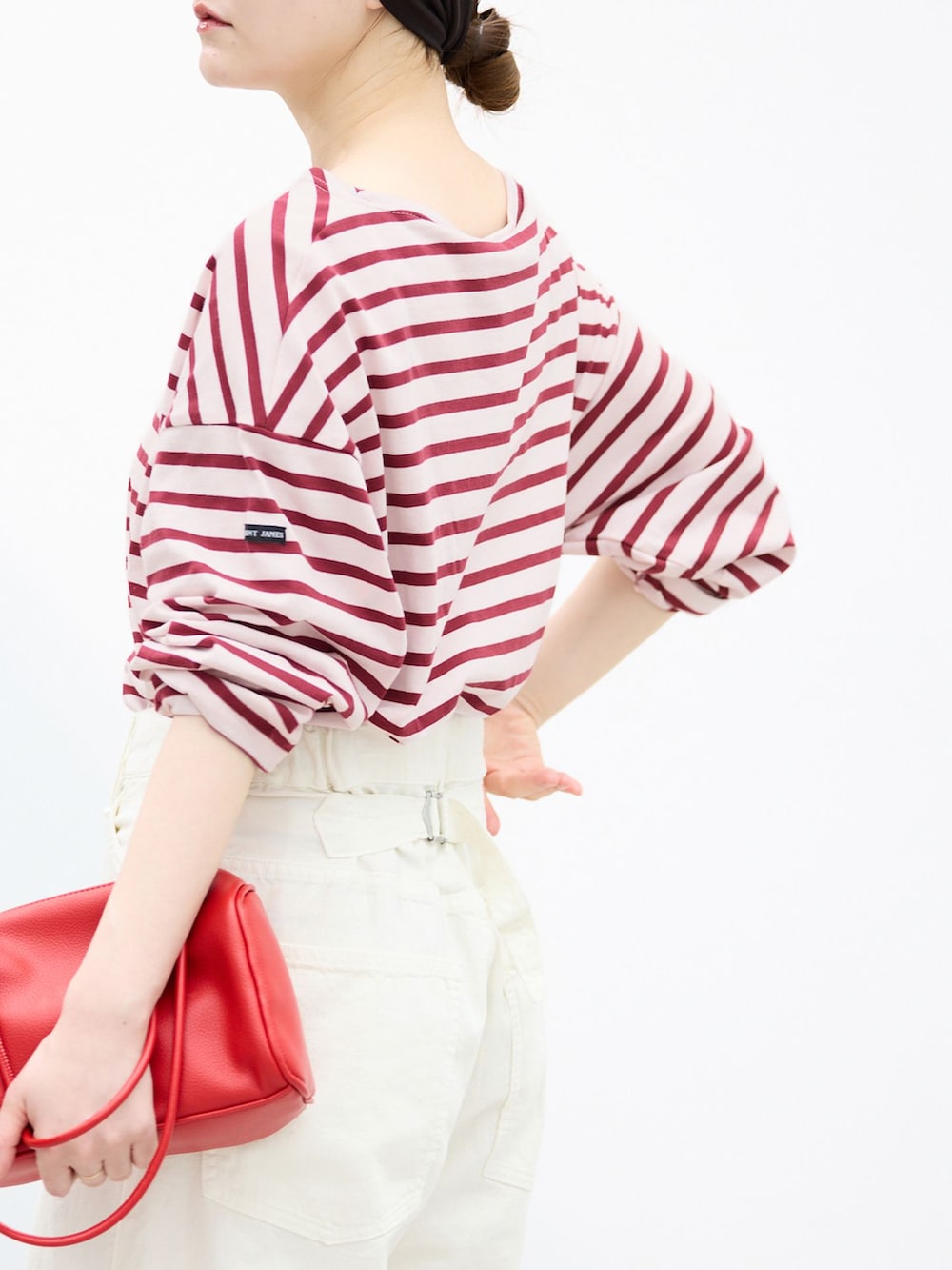 ホワイト系のチノパンツ、レッド系のショルダーバッグ、レッド系のパンプスを着用したレディースの夏コーディネートの6枚目の写真