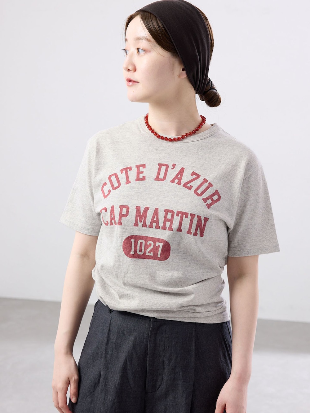 ブラック系のスラックス、グレー系のTシャツ/カットソー、ブラック系のサンダルを着用したレディースの春コーディネートの3枚目の写真