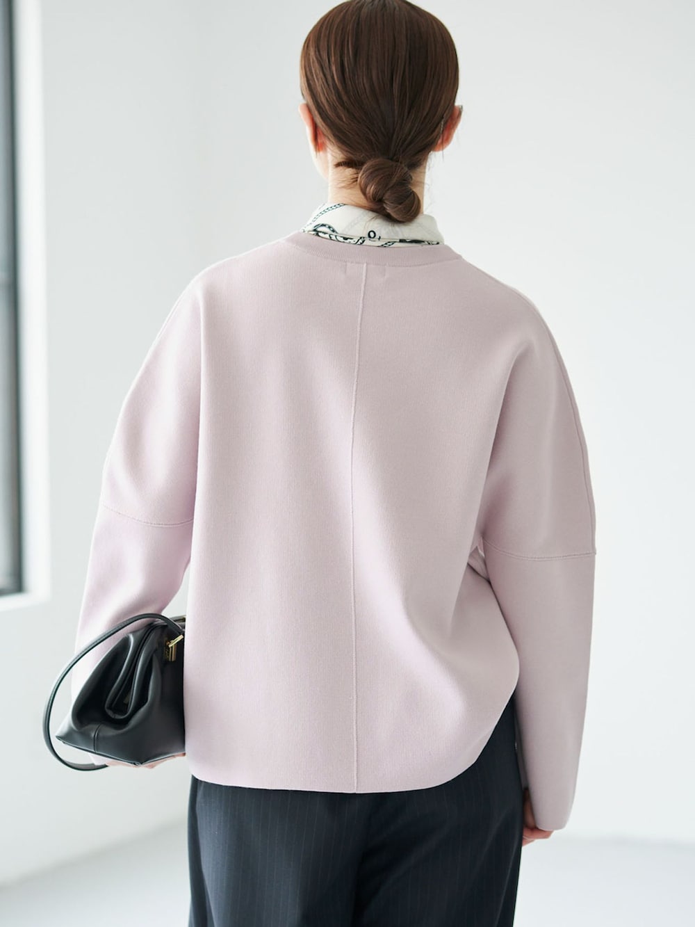ブルー系のその他パンツ、ピンク系のニット/セーター、ブラック系のハンドバッグを着用したレディースの秋コーディネートの5枚目の写真