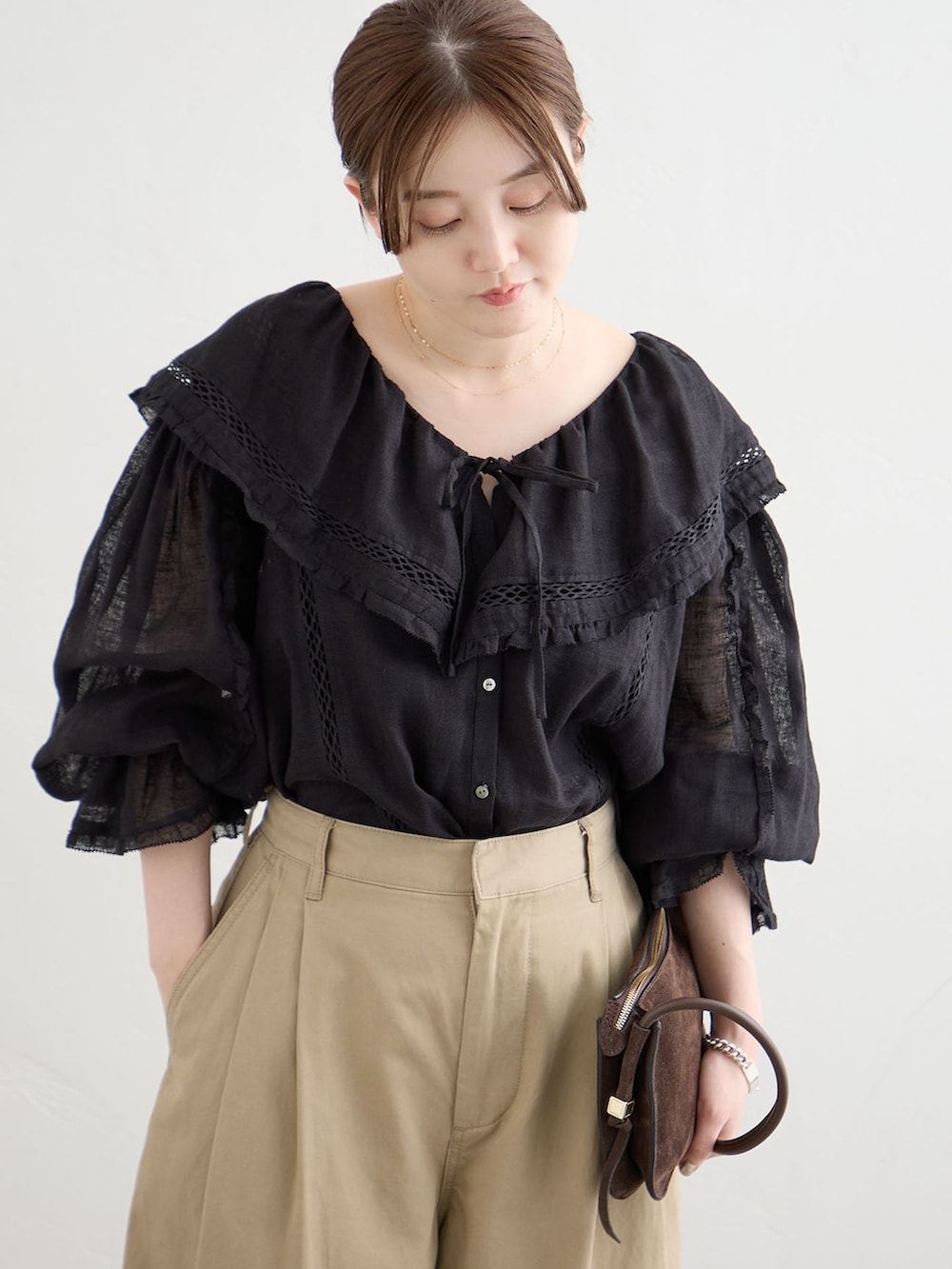 ベージュ系のチノパンツ、ブラック系のシャツ/ブラウスを着用したレディースの夏コーディネートの4枚目の写真