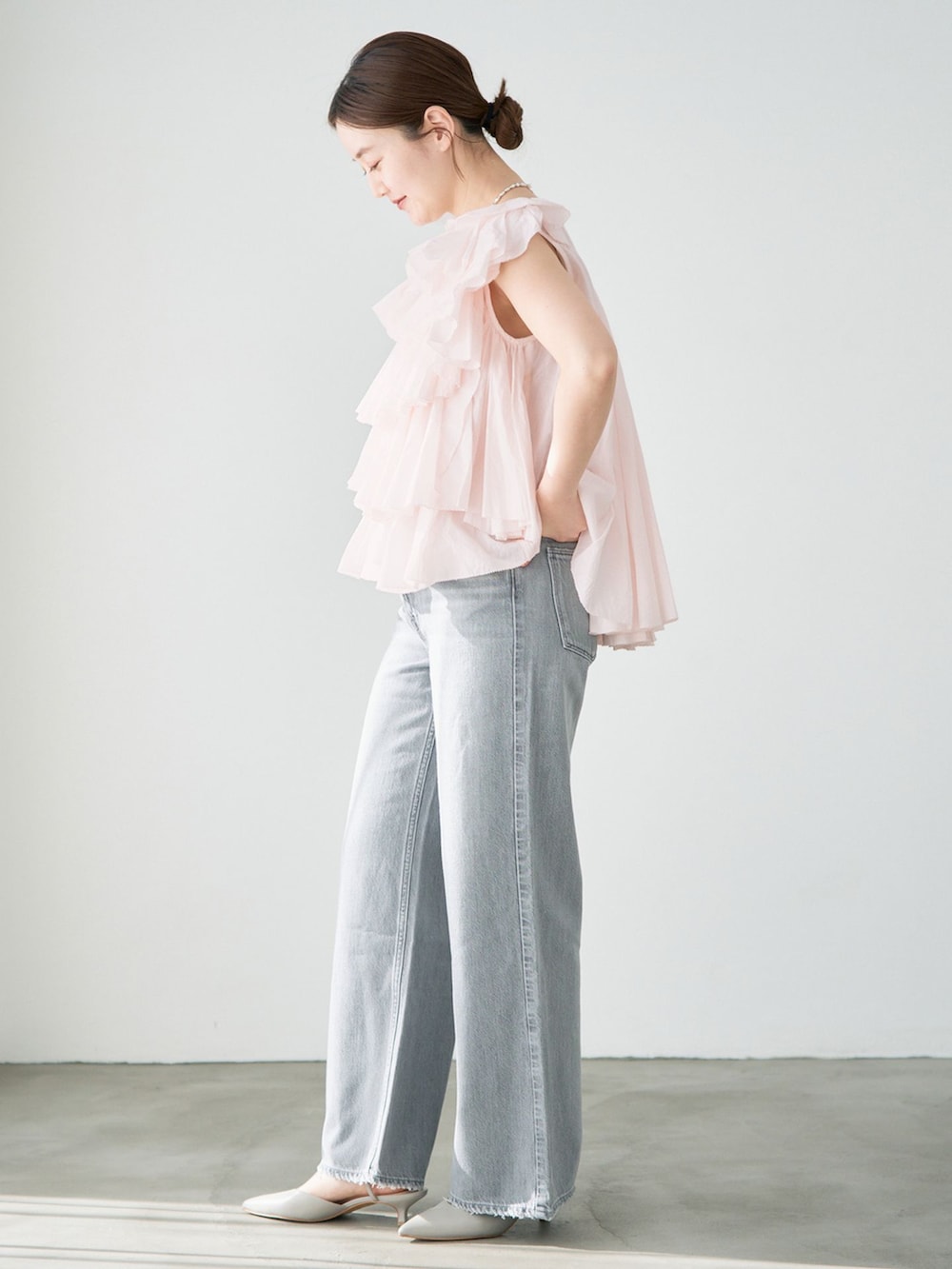 グレー系のデニムパンツ、ピンク系のシャツ/ブラウスを着用したレディースの冬コーディネートの2枚目の写真