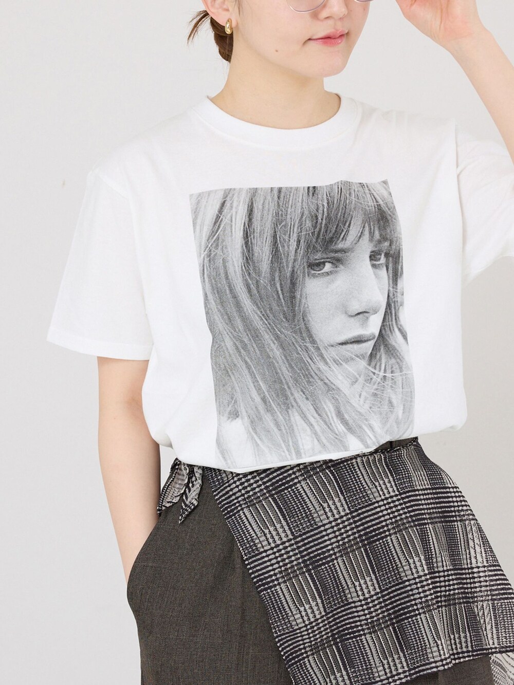 ブラウン系のスラックス、ホワイト系のTシャツ/カットソー、ブラック系のサンダルを着用したレディースの春コーディネートの4枚目の写真