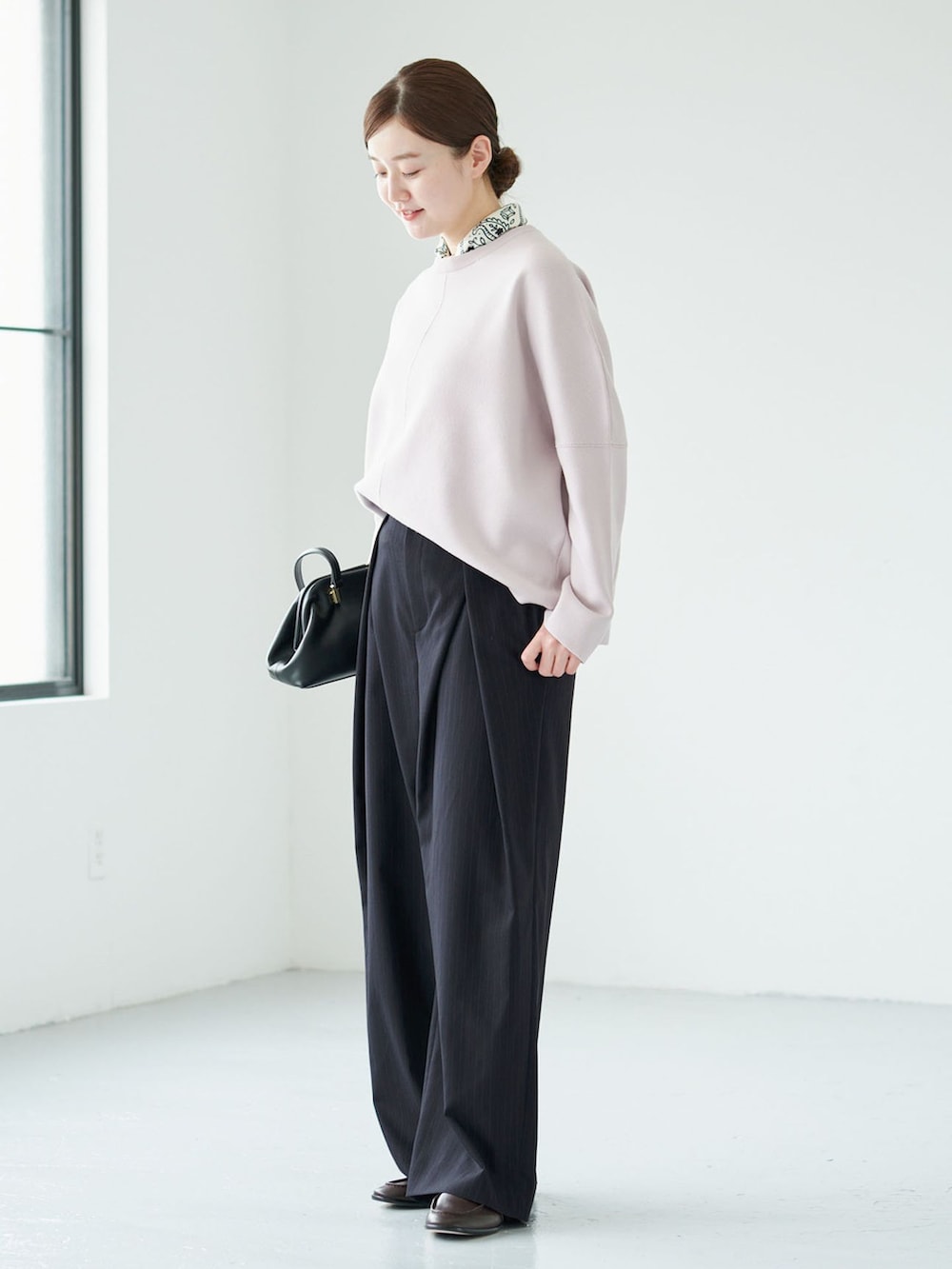 ブルー系のその他パンツ、ピンク系のニット/セーター、ブラック系のハンドバッグを着用したレディースの秋コーディネートの2枚目の写真