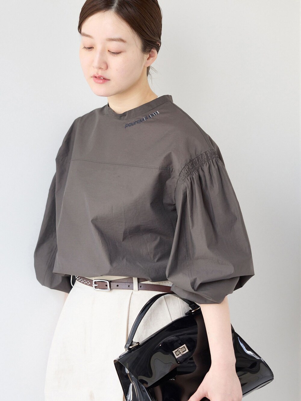 ベージュ系のスラックス、グレー系のシャツ/ブラウス、ブラック系のサンダルを着用したレディースの春コーディネートの4枚目の写真