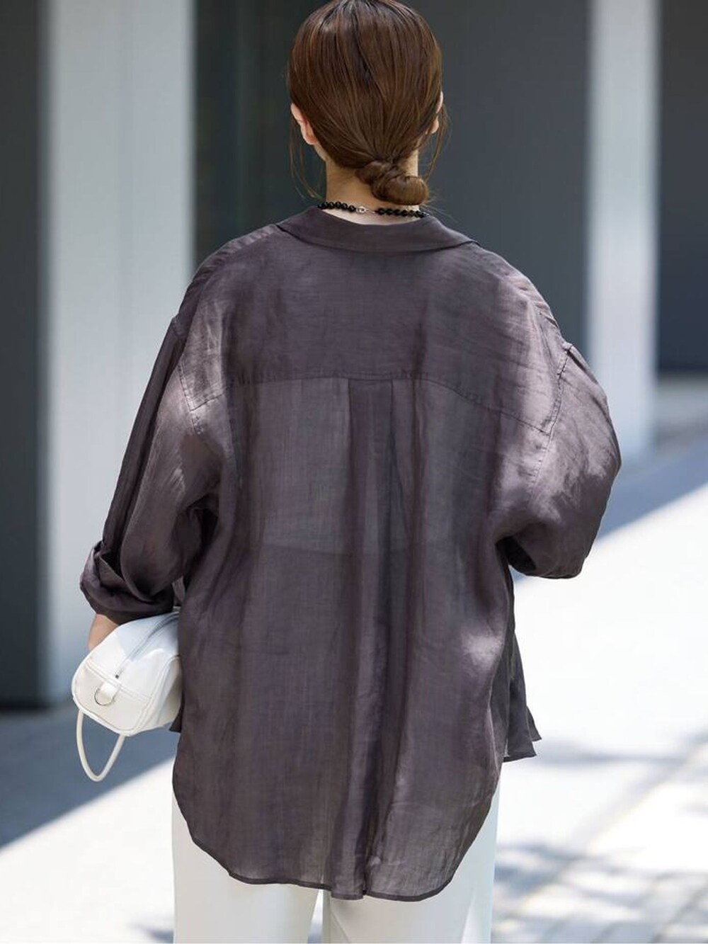 ベージュ系のその他パンツ、ブラック系のシャツ/ブラウス、ホワイト系のショルダーバッグを着用したレディースの春コーディネートの5枚目の写真