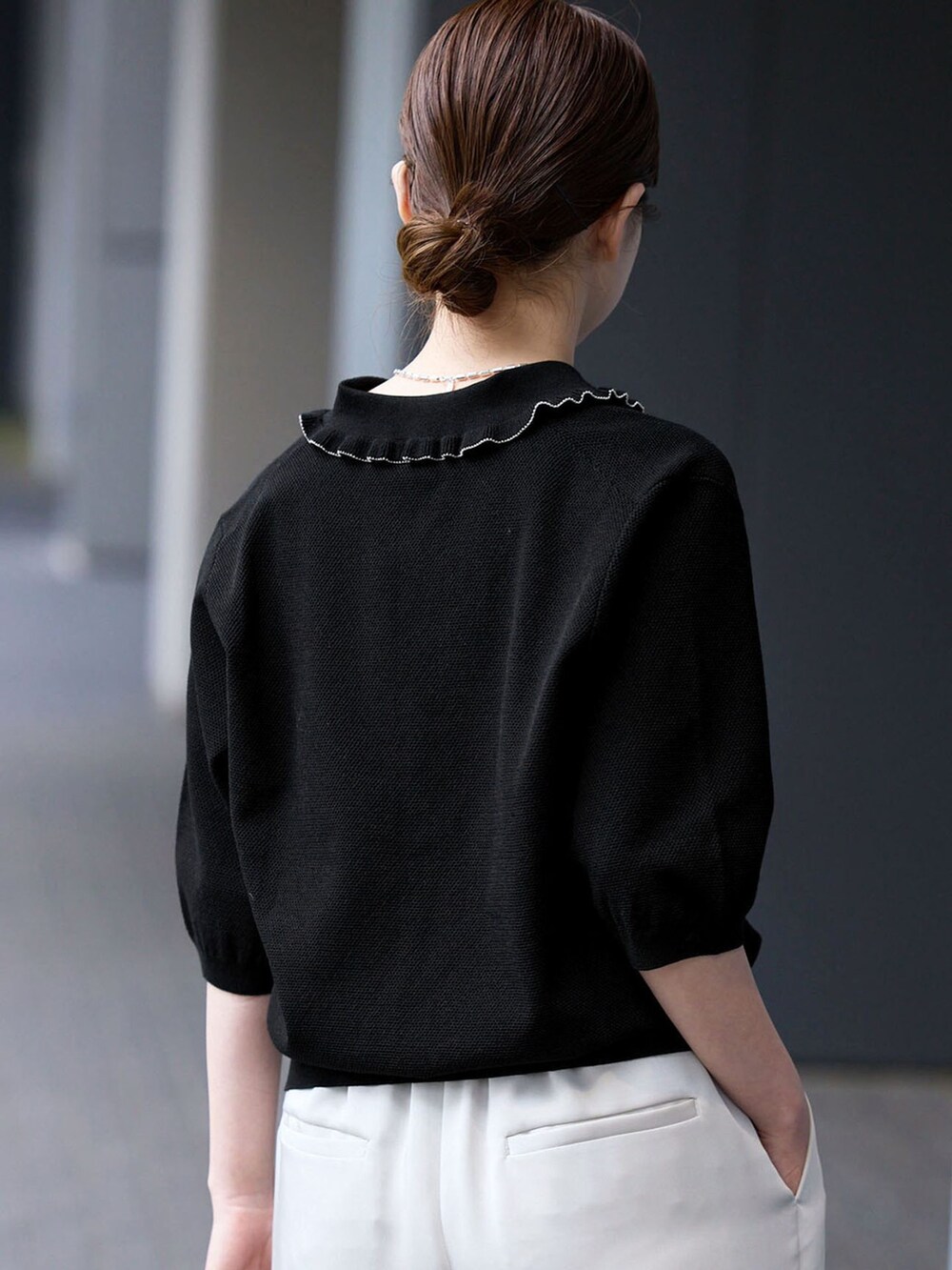 ベージュ系のその他パンツ、ブラック系のニット/セーター、ブラック系のサンダルを着用したレディースの春コーディネートの5枚目の写真