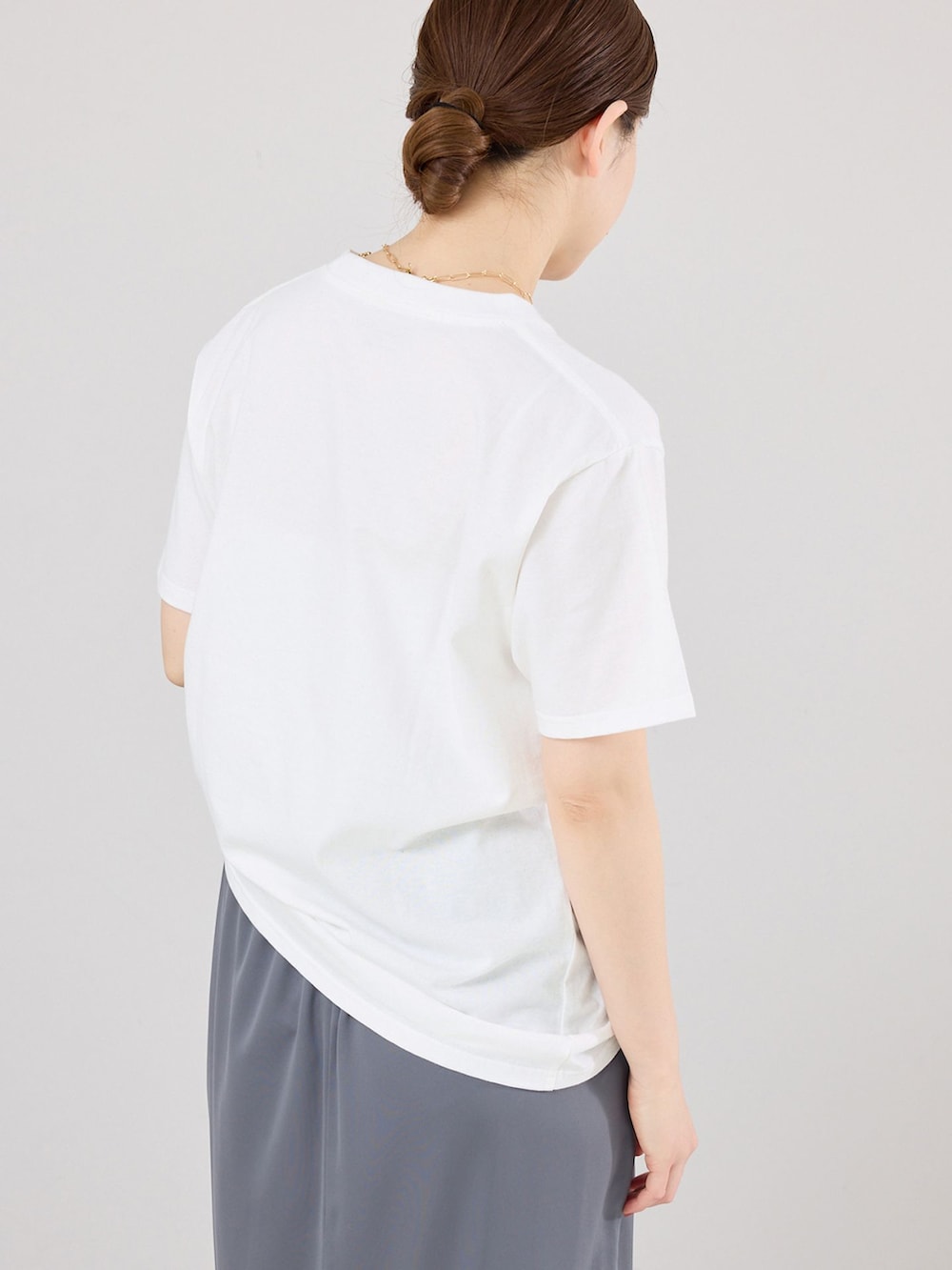 グレー系のスカート、ホワイト系のTシャツ/カットソー、ブラック系のローファーを着用したレディースの春コーディネートの4枚目の写真