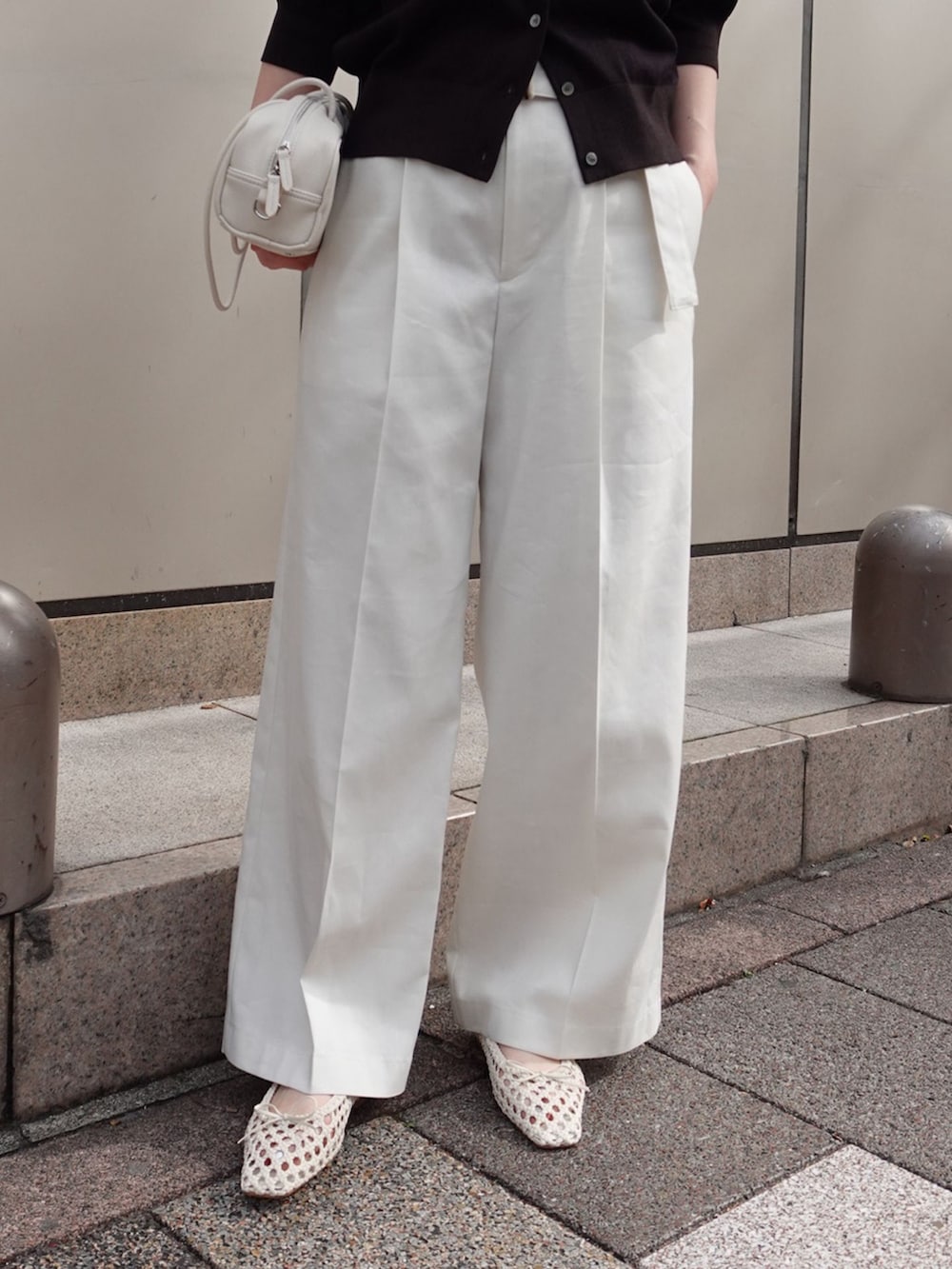 ホワイト系のチノパンツ、ホワイト系のショルダーバッグ、ホワイト系のバレエシューズを着用したレディースの春コーディネートの4枚目の写真