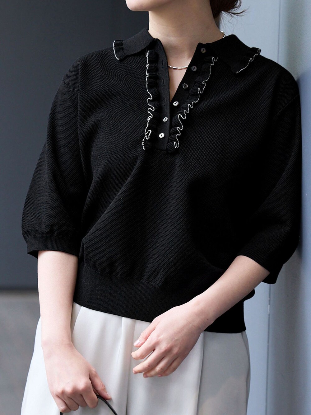 ベージュ系のその他パンツ、ブラック系のニット/セーター、ブラック系のサンダルを着用したレディースの春コーディネートの6枚目の写真
