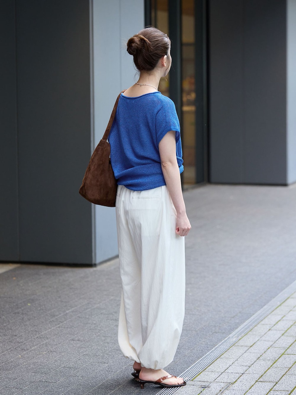 ホワイト系のその他パンツ、ブルー系のニット/セーター、ブラウン系のショルダーバッグを着用したレディースの夏コーディネートの3枚目の写真
