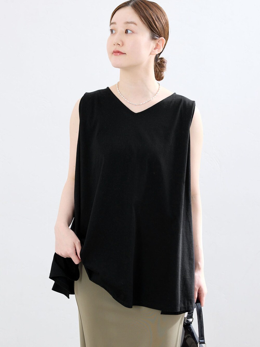 グリーン系のスカート、ブラック系のTシャツ/カットソー、ブラック系のサンダルを着用したレディースの夏コーディネートの4枚目の写真